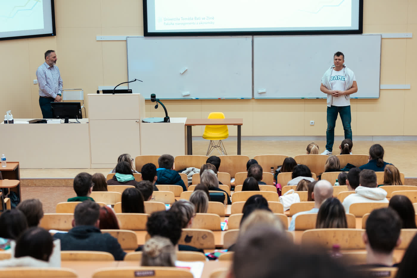 David Tuček v tričku FAME při přednášce pro studenty v aule